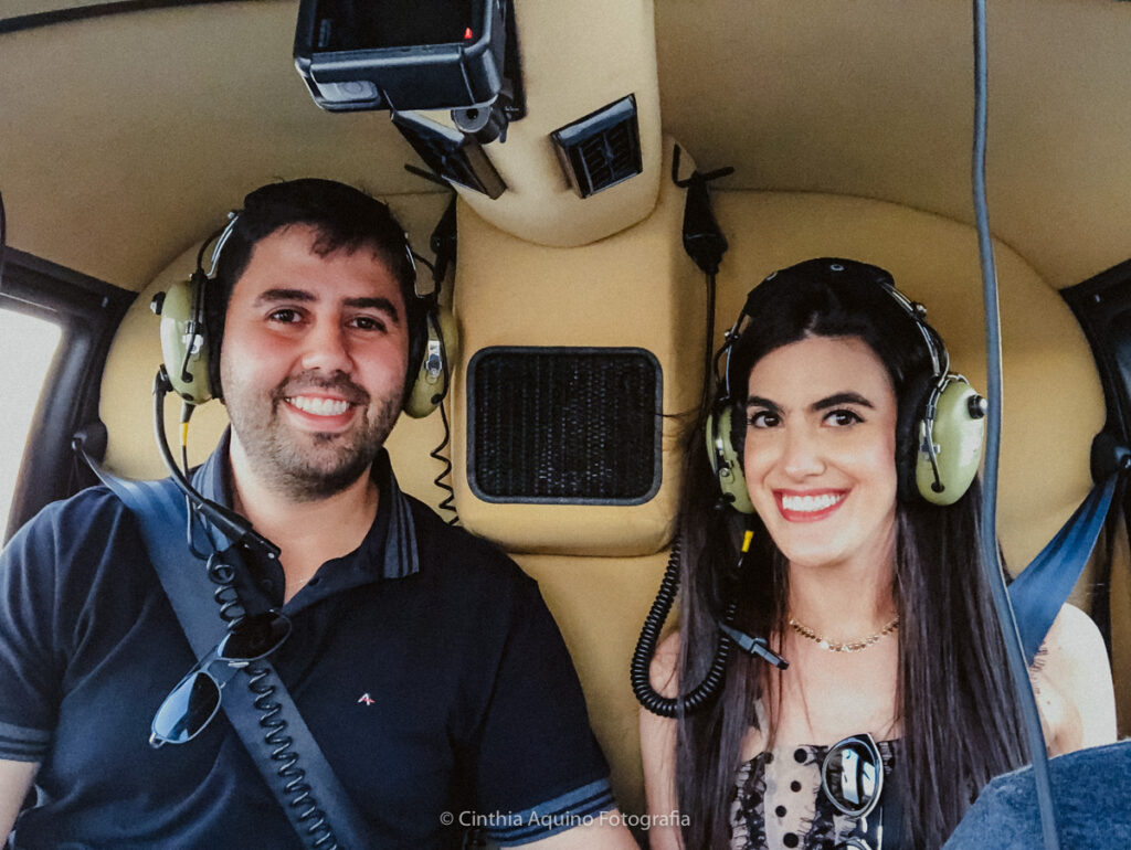 casal no pedido de casamento no helicóptero com letras gigantes